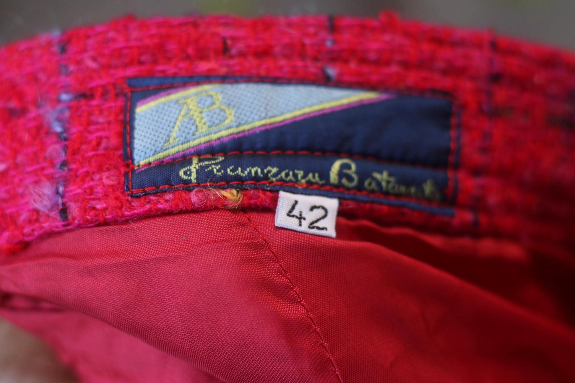 Photograph of the label of the pink vintage skirt. It shows the size of the skirt: vintage 42 and the brand name .