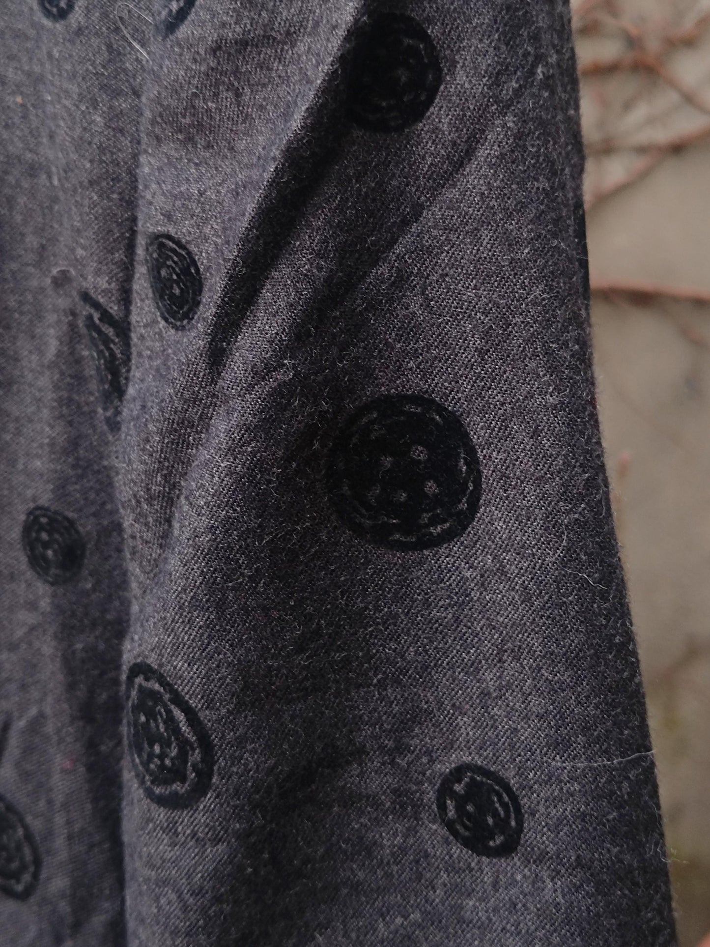 Close-up of a vintage  gray and black polka dotted blazer showing the texture of the fabric